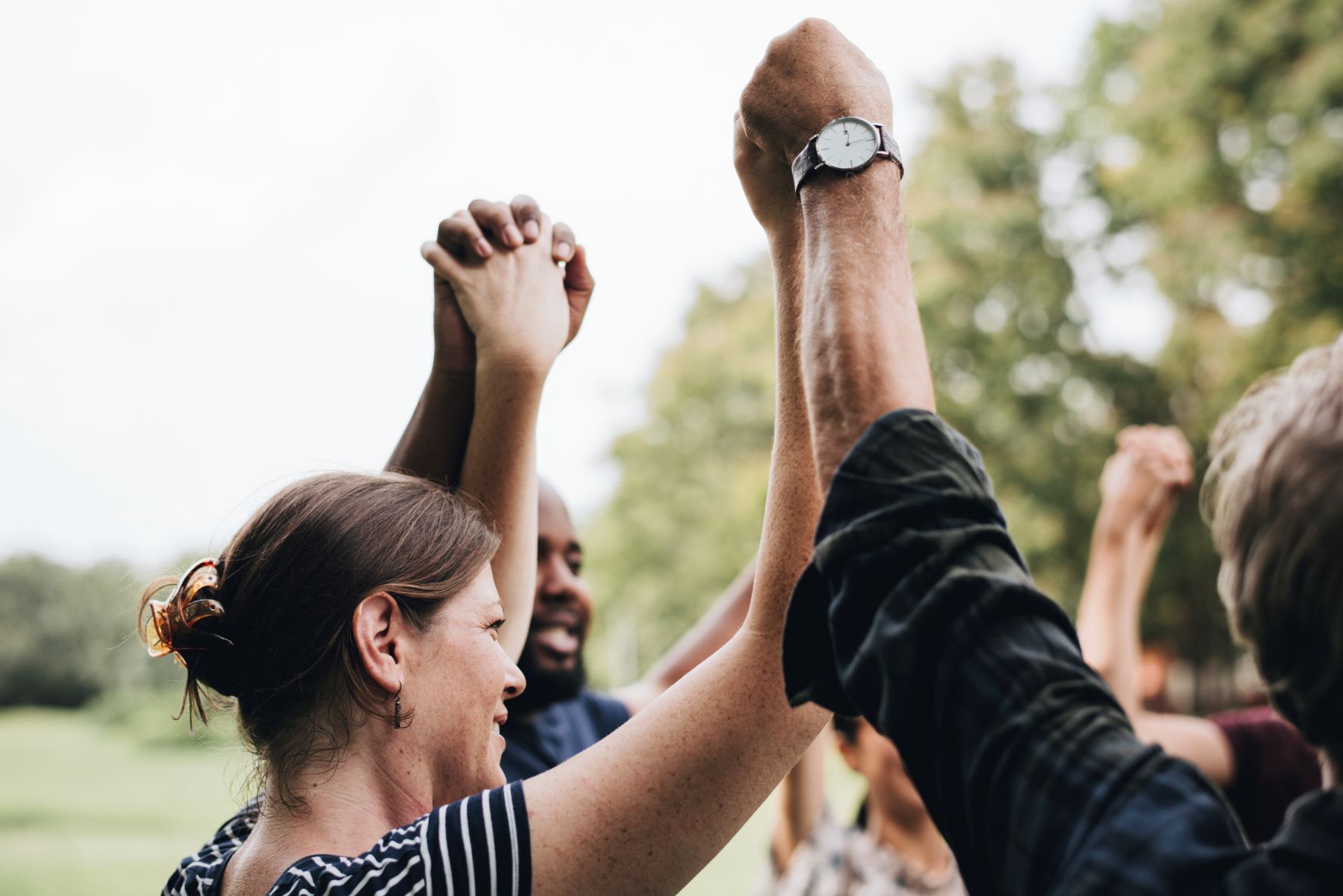 A group of people holding hands with their arms raised