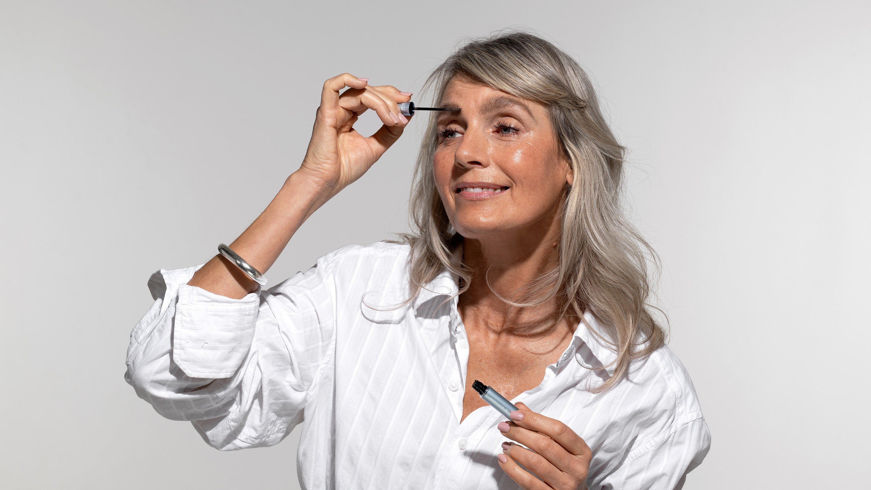 A woman applying mascara